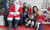 The Neufeld family pose for a photo with Santa. Neufeld family members from left: Bryan, Catherine, Rebecca, Abigail, Amanda, and Natalie.     Tim Brody / Bulletin Photo